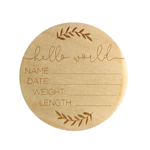 A rustic wooden disk measuring 10cm in diameter, featuring engraved text announcing a newborn's name, birth date, weight, and length. Placed against a soft, neutral background, this charming keepsake embodies the joy and warmth of welcoming a new arrival into the world