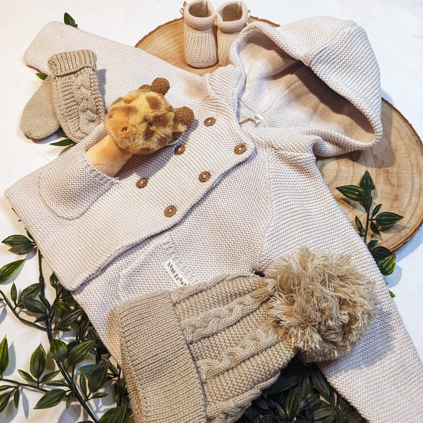 Baby cardigan, knitted in beige organic cotton. Features an adorable hood, double breasted wooden button fastenings and two pockets for practicality. Featuring other baby items available at loobylu baby.