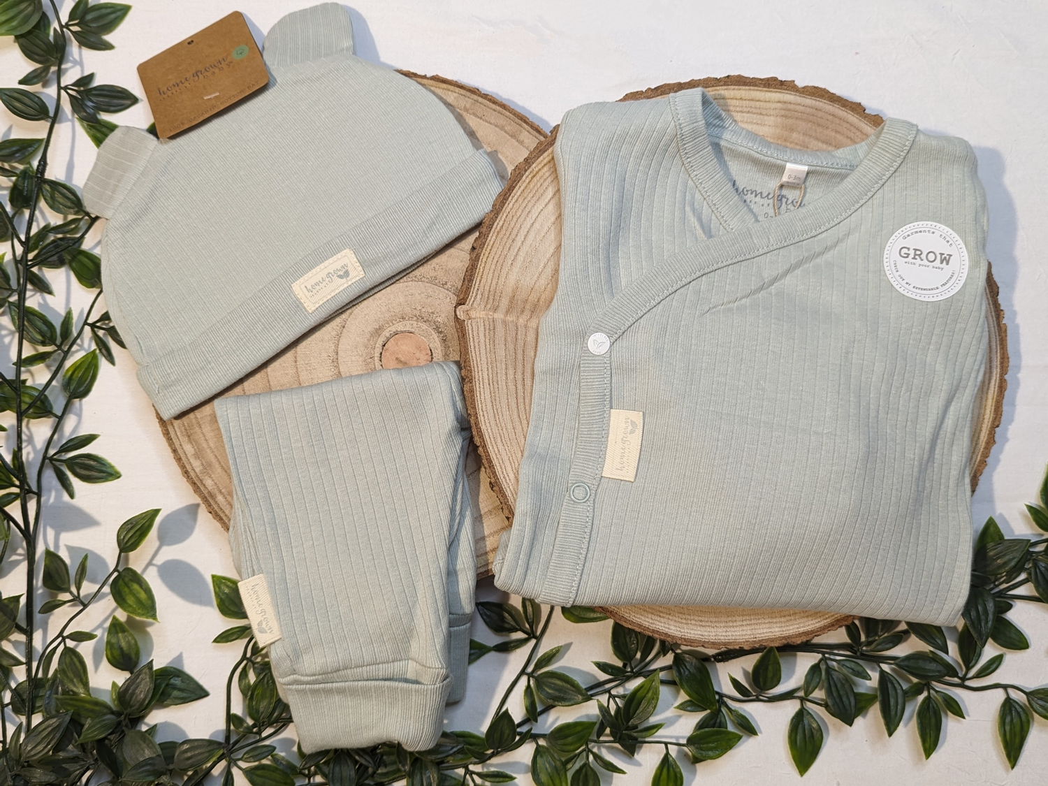 Unisex baby clothes, sage green organic baby three piece set. Includes ribbed sage green organic trousers, bodysuit and hat featuring bear ears.