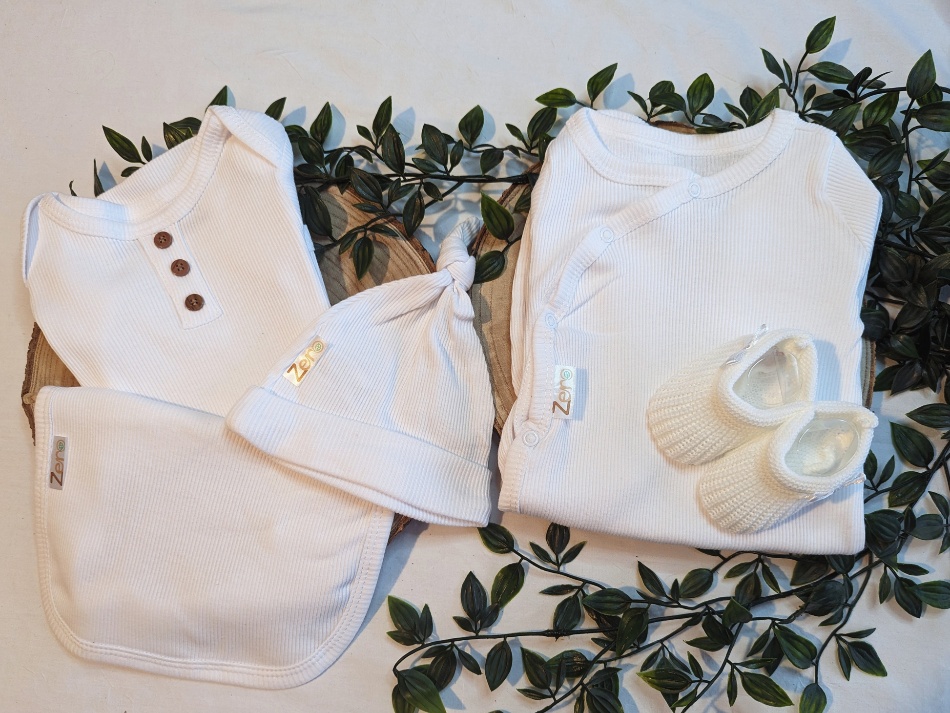 Unisex Baby Clothes - Baby bib in white, ribbed design. Perfect unisex newborn clothing accessory. Featured in a picture with other matching unisex newborn clothes and complementary iteams such as baby booties, baby giraffe teddy and baby mittens available on the loobylu baby website.